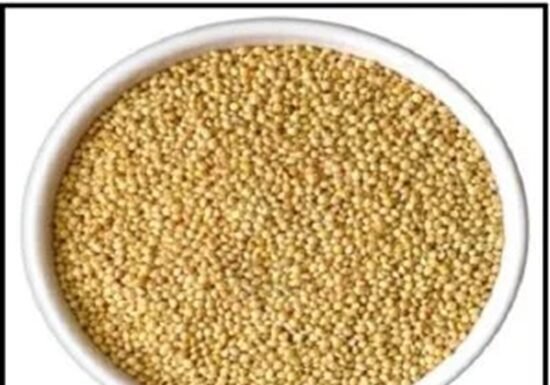 A white bowl filled with small, round, yellow grains of millets benefits