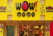 Front entrance of "Wow! Momo" restaurant with bright yellow signage and a staff member visible at the counter inside.