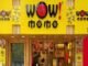 Front entrance of "Wow! Momo" restaurant with bright yellow signage and a staff member visible at the counter inside.