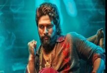 Allu Arjun with a beard and styled hair sits confidently in a colourful shirt and red pants, wearing multiple necklaces, resembling a icon star. The background features a blue-green glow.