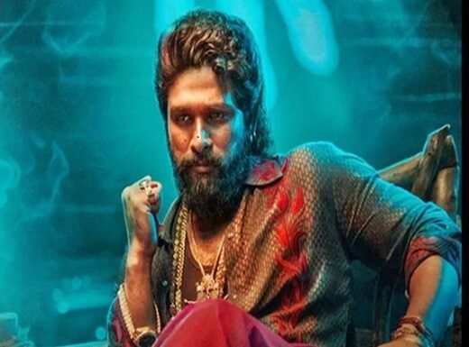 Allu Arjun with a beard and styled hair sits confidently in a colourful shirt and red pants, wearing multiple necklaces, resembling a icon star. The background features a blue-green glow.