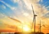 Wind turbines elegantly silhouette the hill at sunset, with "sustainable energy" emblazoned across the scene, capturing the essence of renewable power.