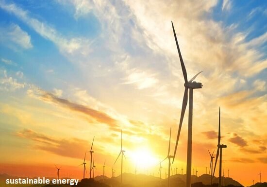 Wind turbines elegantly silhouette the hill at sunset, with "sustainable energy" emblazoned across the scene, capturing the essence of renewable power.