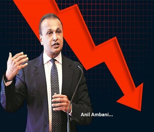 A man in a suit, possibly channeling Anil Ambani insightful demeanor, gestures while speaking, with a prominent red downward arrow in the background.