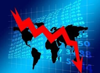 A red downward arrow in front of a world map and financial numbers highlights a global market decline, with particular implications for Indian economy slowing down