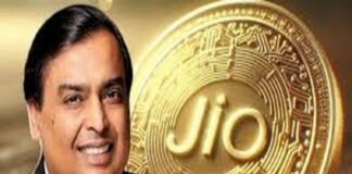 A smiling man in a suit stands proudly in front of a large Jio Coin, its embossed, circuit-like design gleaming with innovation.