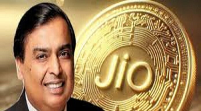 A smiling man in a suit stands proudly in front of a large Jio Coin, its embossed, circuit-like design gleaming with innovation.