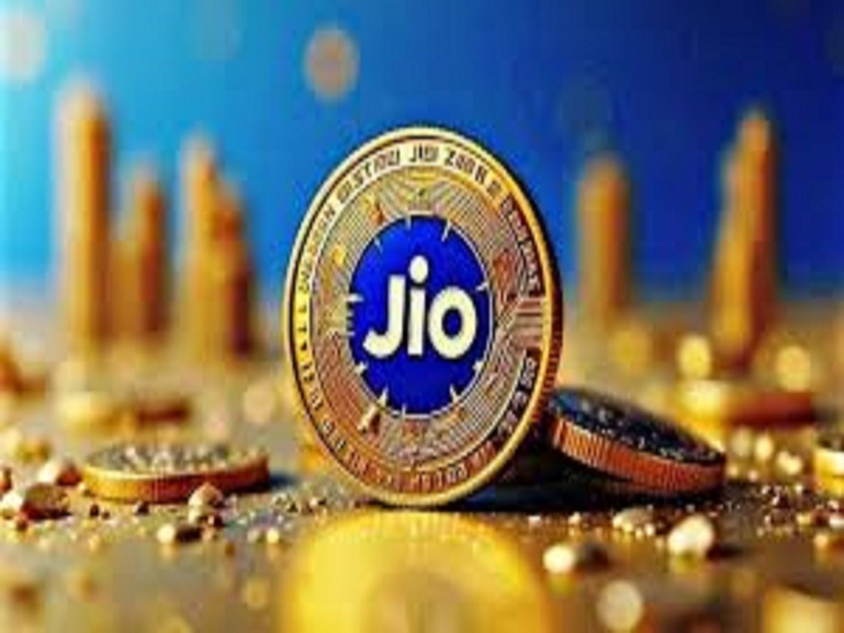 A golden Jio coin with a striking blue center and the iconic logo is surrounded by smaller shimmering coins, set against a backdrop of blurred vertical elements.