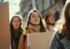 A group of unskilled or underemployed individuals holding signs during a daytime protest.